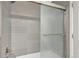 Bathroom with gray tiled walls and shower including glass sliding door and modern fixtures at 1465 Red Cliff Way, Castle Rock, CO 80109