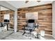 Bedroom with wooden accent wall, modern desk, chair and mirror closet with hardwood-style floors at 1465 Red Cliff Way, Castle Rock, CO 80109