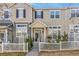 Inviting two-story townhouse with neutral siding, dark shutters, and charming white picket fence in front at 1465 Red Cliff Way, Castle Rock, CO 80109