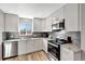 Well-lit kitchen with white cabinets, stainless steel appliances, granite countertops, and modern backsplash at 1465 Red Cliff Way, Castle Rock, CO 80109