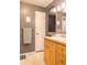 Neutral bathroom with a tub shower, a single sink vanity, and a mirror with decorative lighting at 7150 S Curtice St, Littleton, CO 80120