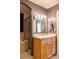Well-lit bathroom featuring a bathtub with tile surround, a vanity with storage, and modern fixtures at 7150 S Curtice St, Littleton, CO 80120