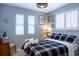 Bright bedroom with white shuttered windows, a cozy bed, and blue painted walls at 7150 S Curtice St, Littleton, CO 80120