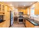 Bright kitchen with light wood cabinets, stainless steel appliances, and black countertops overlooking dining area at 7150 S Curtice St, Littleton, CO 80120