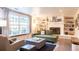 Cozy living room with a fireplace, built-in shelves, and ample natural light at 7150 S Curtice St, Littleton, CO 80120