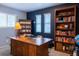 Home office features a large desk, ample storage with bookshelves, and two bright, shuttered windows at 7150 S Curtice St, Littleton, CO 80120