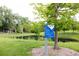 Park features a serene pond, lush greenery, and clear signage outlining park rules at 7150 S Curtice St, Littleton, CO 80120