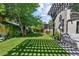 Expansive backyard features a large grassy area with mature trees, a playset, and an outdoor seating area at 1265 S Gaylord St, Denver, CO 80210