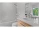 Bright bathroom featuring subway tile, white vanity with a light wood grain, and a shower-tub combo at 1265 S Gaylord St, Denver, CO 80210