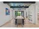 Dining room featuring a long wooden table, statement chandelier, and open shelving near living area at 1265 S Gaylord St, Denver, CO 80210