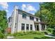 View of the side of the house showing landscaped yard and a white brick exterior and black window frames at 1265 S Gaylord St, Denver, CO 80210