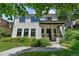 Charming two-story home with a white brick exterior and landscaped front yard with black window frames at 1265 S Gaylord St, Denver, CO 80210