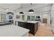 Elegant kitchen with an island, designer lighting, stainless appliances, seamlessly connected to the living room at 1265 S Gaylord St, Denver, CO 80210