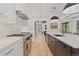 Well-lit kitchen with modern appliances, a kitchen island, and a stylish marble backsplash at 1265 S Gaylord St, Denver, CO 80210