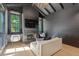 Stylish living room featuring a dark fireplace, wood paneling, and cozy seating by the window at 1265 S Gaylord St, Denver, CO 80210