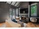 Charming living room features a fireplace, TV, white couch, and two work stations near windows at 1265 S Gaylord St, Denver, CO 80210