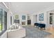 Bright living room with a fireplace, gray sofa, blue chairs, and large windows with white shutters at 1265 S Gaylord St, Denver, CO 80210