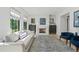 Bright living room with a fireplace, gray sofa, blue chairs, and large windows with white shutters at 1265 S Gaylord St, Denver, CO 80210