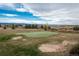 Beautiful backyard with a putting green and scenic mountain views in the distance at 8871 Aspen Leaf Ct, Littleton, CO 80125