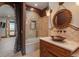 Bathroom featuring a soaking tub with custom tilework, a decorative mirror, and elegant fixtures at 8871 Aspen Leaf Ct, Littleton, CO 80125