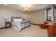 Bright bedroom featuring neutral walls, carpet, chandelier, and a window view at 8871 Aspen Leaf Ct, Littleton, CO 80125