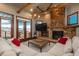 Cozy living room features a stone fireplace, wood beams, and access to the outdoor deck at 8871 Aspen Leaf Ct, Littleton, CO 80125