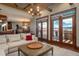 Bright living room with fireplace, wood beams, deck access, and views at 8871 Aspen Leaf Ct, Littleton, CO 80125