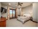 Serene main bedroom with private balcony access, a ceiling fan, and large windows with scenic views at 8871 Aspen Leaf Ct, Littleton, CO 80125