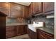 Pantry with dark wood cabinets, tile backsplash, and a farmhouse sink at 8871 Aspen Leaf Ct, Littleton, CO 80125