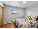 Comfortable bedroom featuring a colorful bedspread, a window view, and hardwood floors at 11600 W 31St Pl, Lakewood, CO 80215