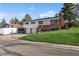 Lovely home featuring a two-car garage, brick accents, and lush landscaping with a well-kept front lawn at 11600 W 31St Pl, Lakewood, CO 80215