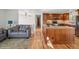 Open-concept space with hardwood floors and a large kitchen island and adjacent Gathering room with sofa at 11600 W 31St Pl, Lakewood, CO 80215