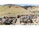 Expansive aerial shot showcases a neighborhood nestled against a backdrop of rolling hills and clear blue skies at 789 Zamia Ave, Boulder, CO 80304