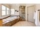 A bathroom featuring a soaking tub, glass enclosed shower, and tiled floors at 789 Zamia Ave, Boulder, CO 80304