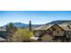 A view of the tan home with a stone foundation nestled among trees in the mountains at 789 Zamia Ave, Boulder, CO 80304