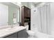 Well-lit bathroom featuring a shower with a curtain, dark shelving, and vanity sink at 1694 Castle Vista Way, Castle Rock, CO 80104