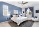 Stylish bedroom with a large window, chic rug, comfortable chair, and modern ceiling fan creates a serene space at 1694 Castle Vista Way, Castle Rock, CO 80104