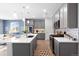 Bright kitchen featuring gray cabinets, stainless appliances, backsplash, and an island with a sink at 1694 Castle Vista Way, Castle Rock, CO 80104