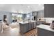 Open-concept kitchen featuring gray cabinets, stainless appliances, island, and access to living area and outdoor patio at 1694 Castle Vista Way, Castle Rock, CO 80104