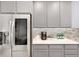 Close-up of kitchen area featuring stainless steel refrigerator, light grey cabinets, and tile backsplash at 1694 Castle Vista Way, Castle Rock, CO 80104