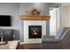 Living room fireplace with rustic mantel and modern tile surround at 7800 E 148Th Dr, Thornton, CO 80602