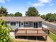 Back exterior with a wood deck, blue siding, and a well-maintained lawn at 2155 S Deframe St, Lakewood, CO 80228