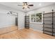 Bedroom with hardwood floors, built-in shelves, window view, and large closet with mirror at 2155 S Deframe St, Lakewood, CO 80228