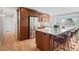 This renovated kitchen features stainless steel appliances, wood cabinets, granite counters, and an island with seating at 2155 S Deframe St, Lakewood, CO 80228