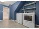 Well-lit laundry room with modern washer and dryer, storage shelves, and blue walls at 2155 S Deframe St, Lakewood, CO 80228
