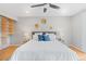 Serene main bedroom with a soft color palette, built-in shelving, hardwood floors, and ceiling fan at 2155 S Deframe St, Lakewood, CO 80228
