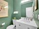 Stylish bathroom with white vanity, modern fixtures, and a decorative mirror at 2716 W Greens Dr, Littleton, CO 80123