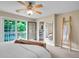 Bedroom with ceiling fan and balcony access offers tranquil views of greenery and a convenient closet at 2716 W Greens Dr, Littleton, CO 80123