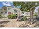 Exterior of a multi-Gathering unit with a small patio, grill, and light-yellow siding surrounded by bushes and trees at 10752 E Exposition Ave # 332, Aurora, CO 80012