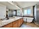 Beautiful bathroom featuring double sinks, granite countertops, a freestanding tub, and a luxurious walk-in shower at 12408 W 83Rd Ave, Arvada, CO 80005